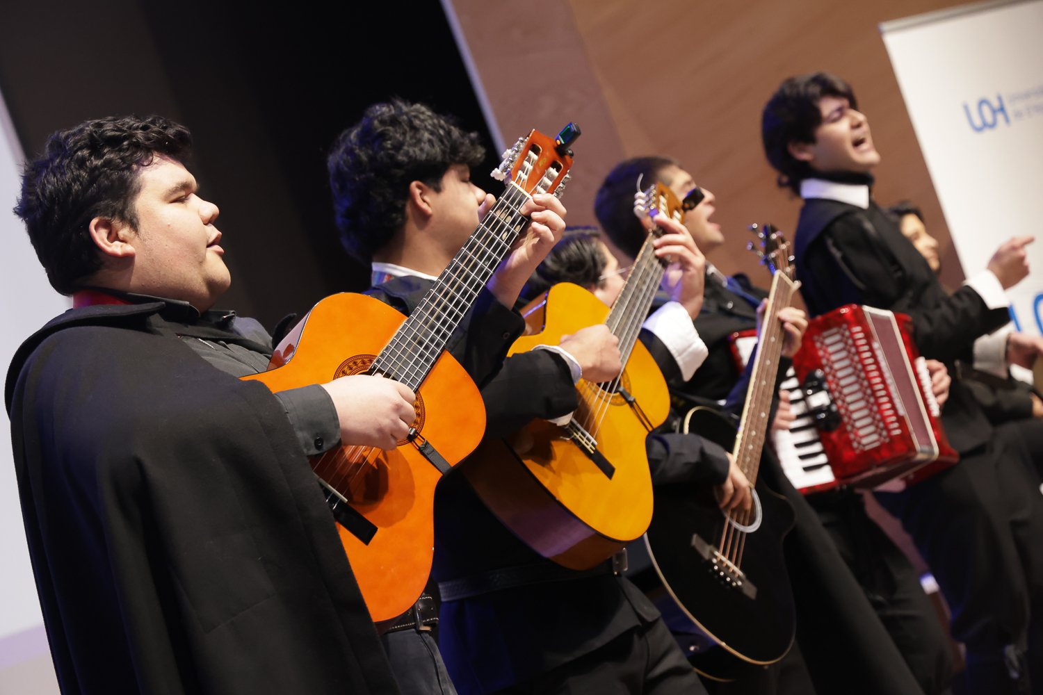 Músicos con guitarras y acordeón durante una presentación.