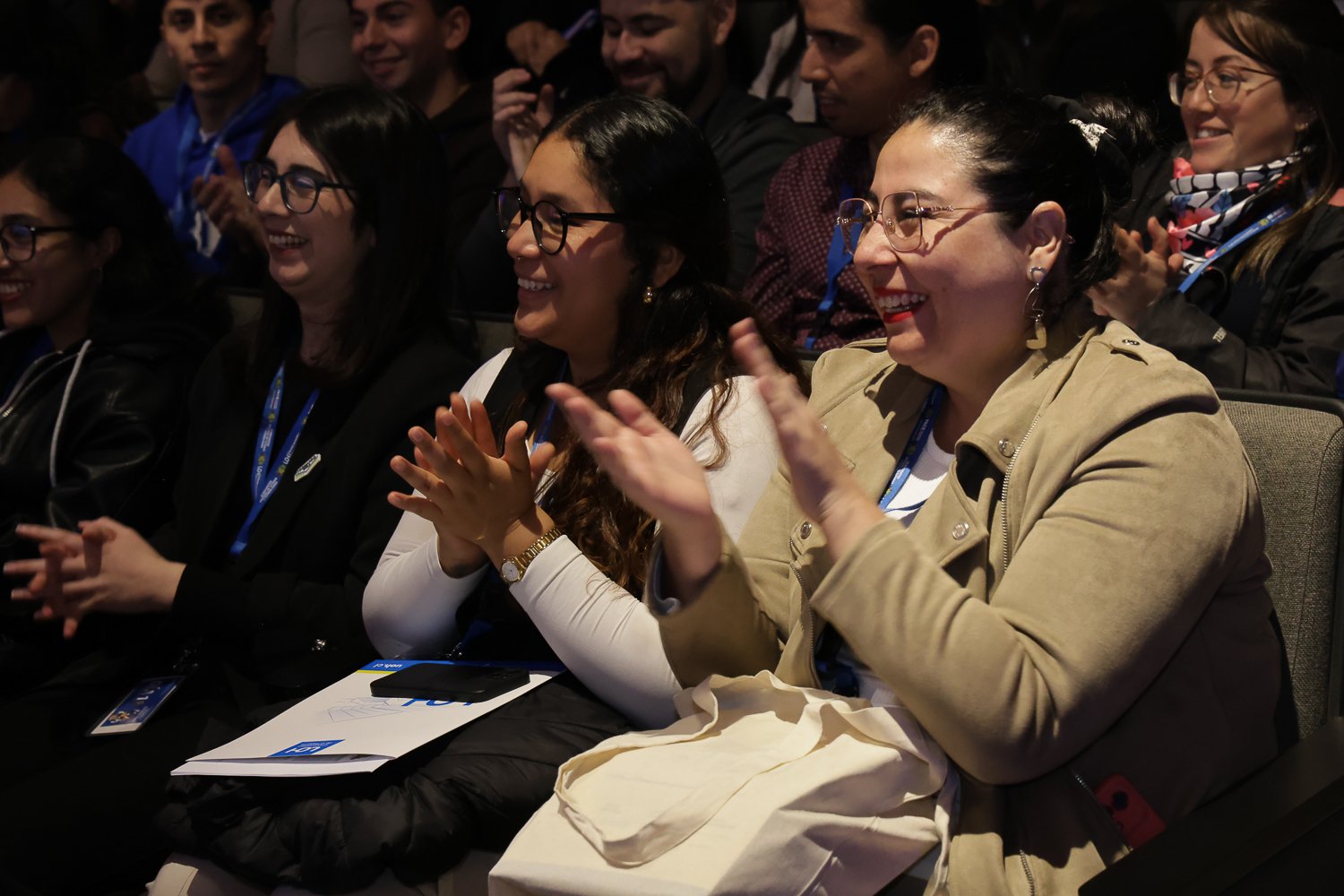 Participantes aplauden desde las butacas del auditorio.
