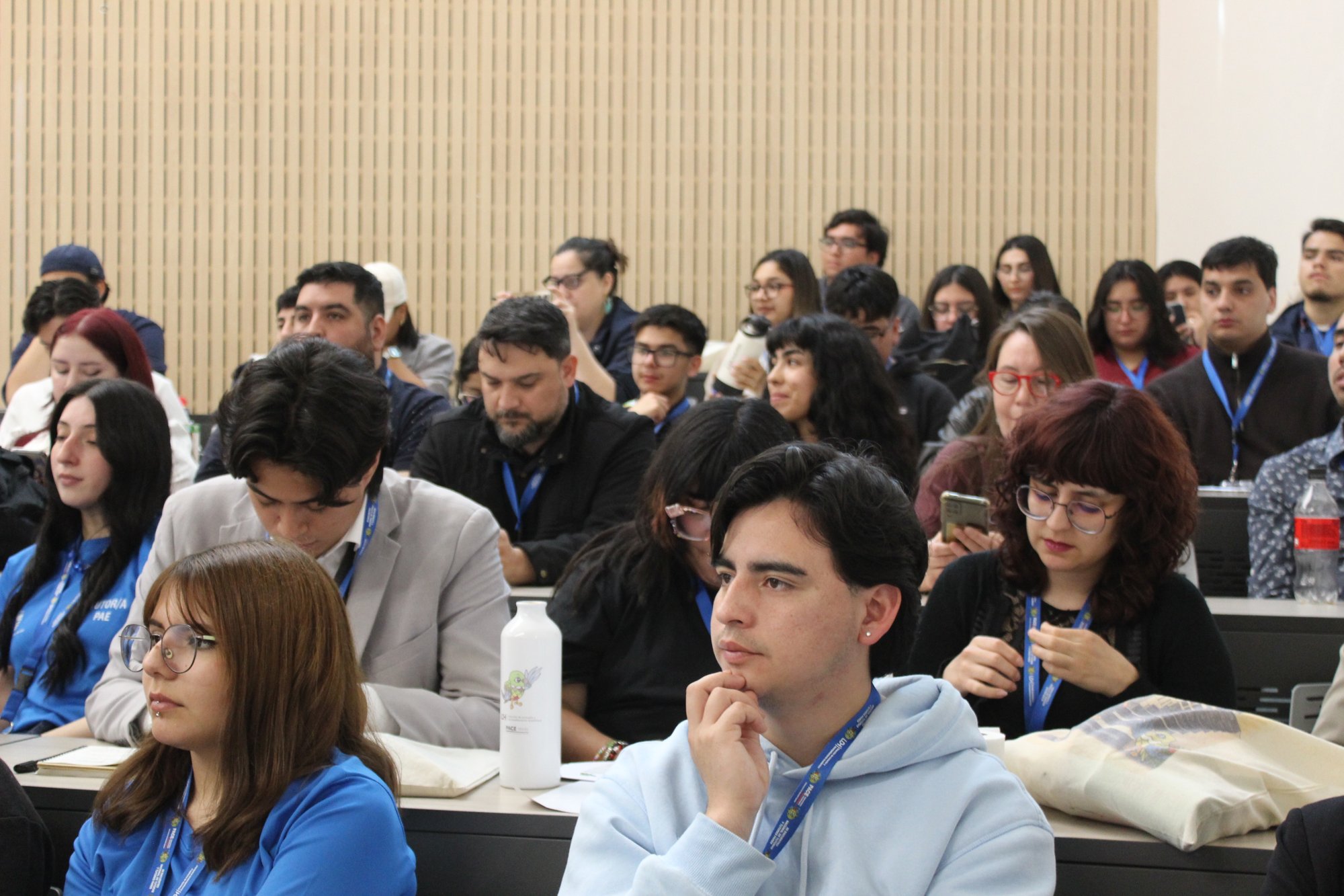 Asistentes escuchan una exposición en una sala de clases.