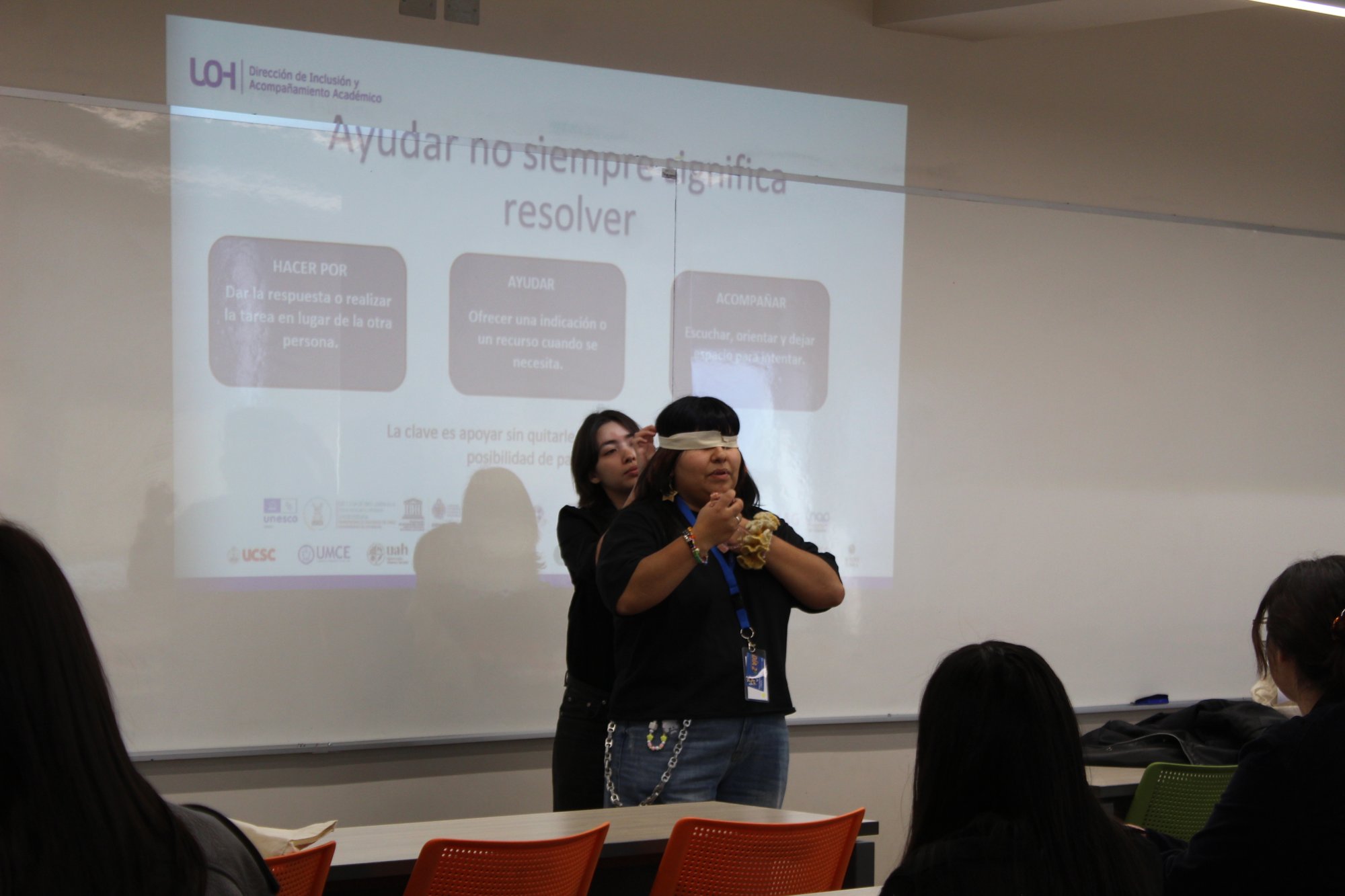 Dos participantes realizan una dinámica frente a una proyección.