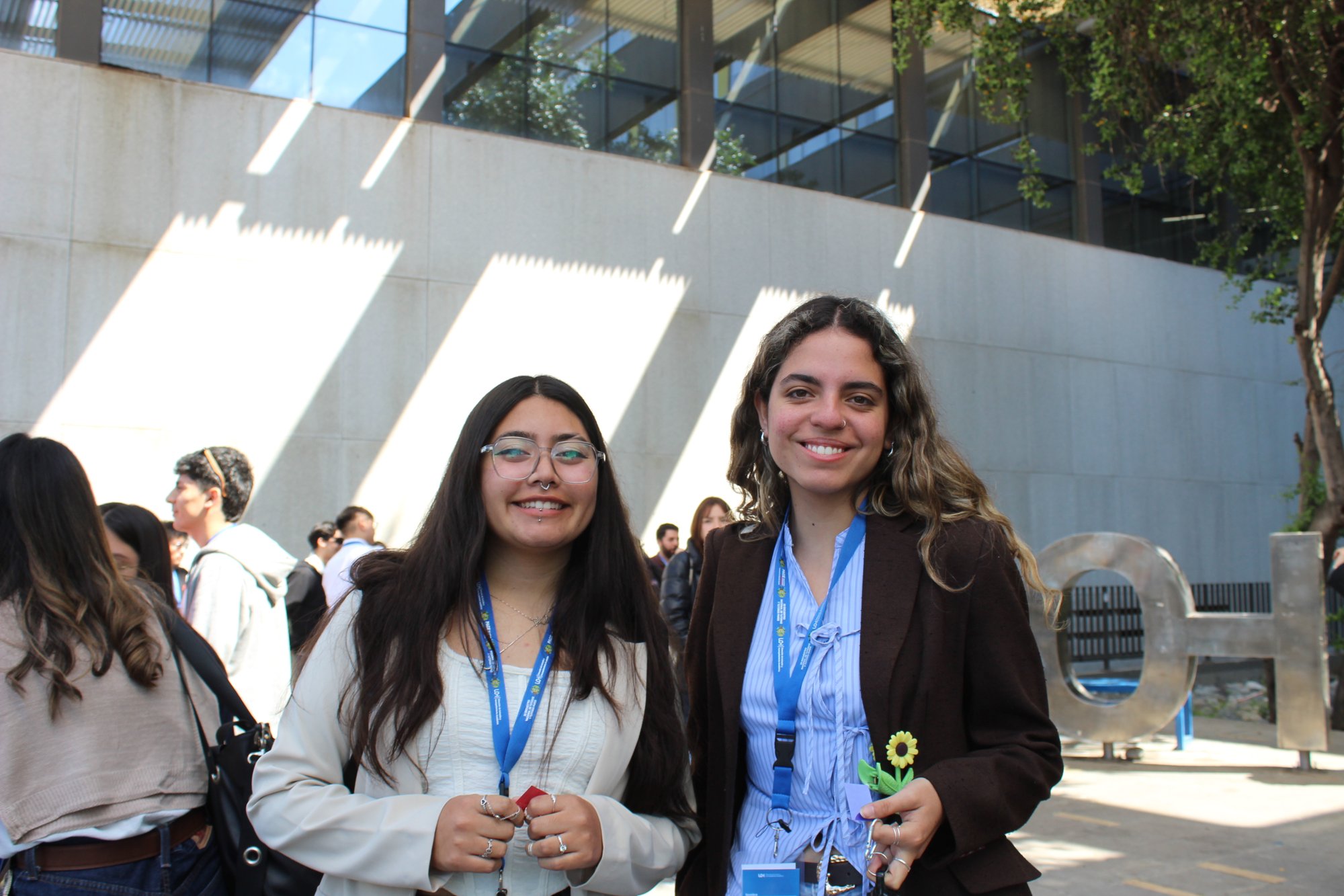 Dos participantes conversan en el exterior del campus.