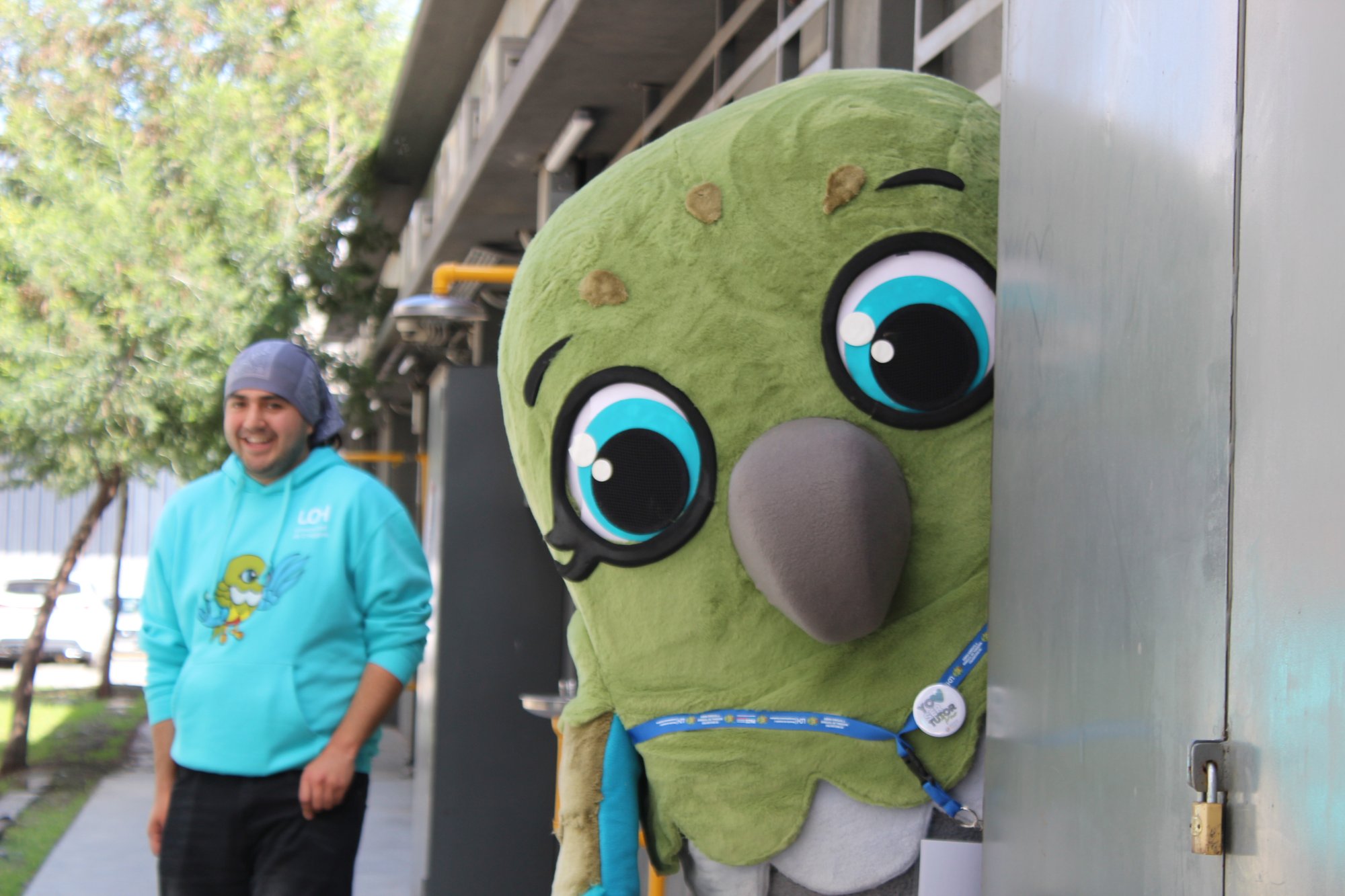 Integrante del equipo junto a la mascota del encuentro.