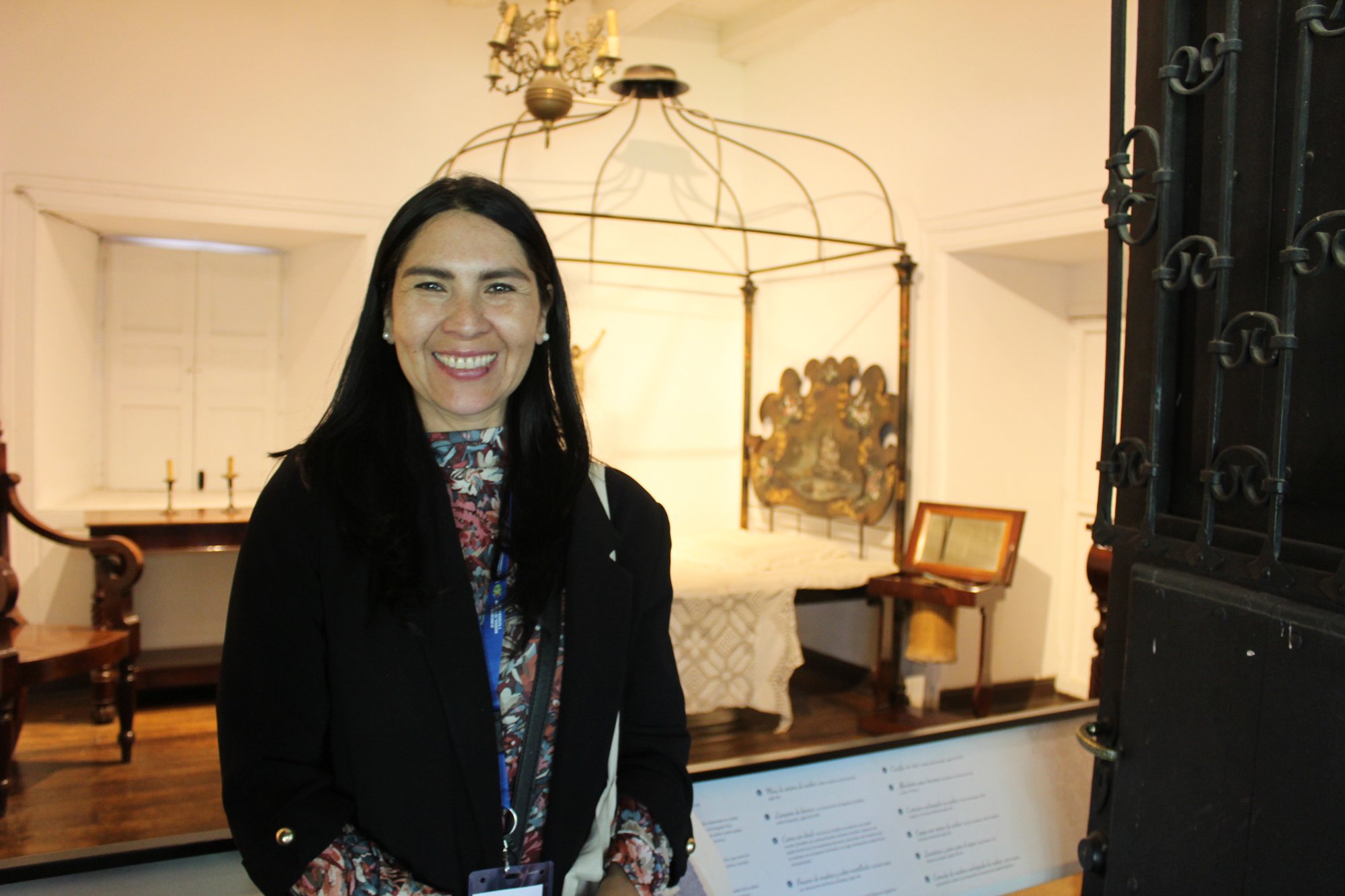 Una persona posa en una sala con muebles y objetos de exposición.
